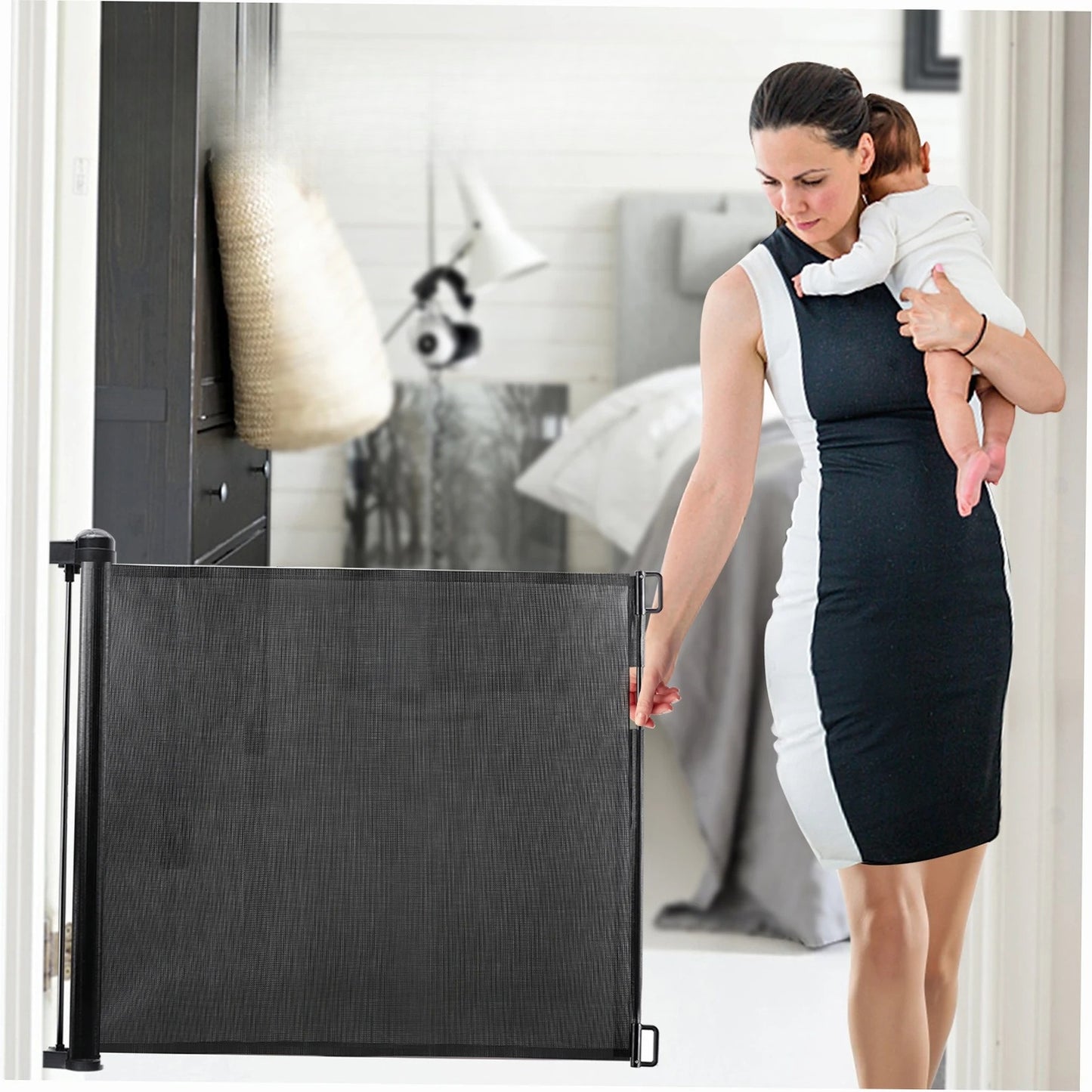 Retractable dog gate used as a child safety barrier while a parent holds a baby in a home hallway