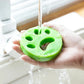 Reusable green pet hair remover rinsed under running water for easy cleaning and reuse