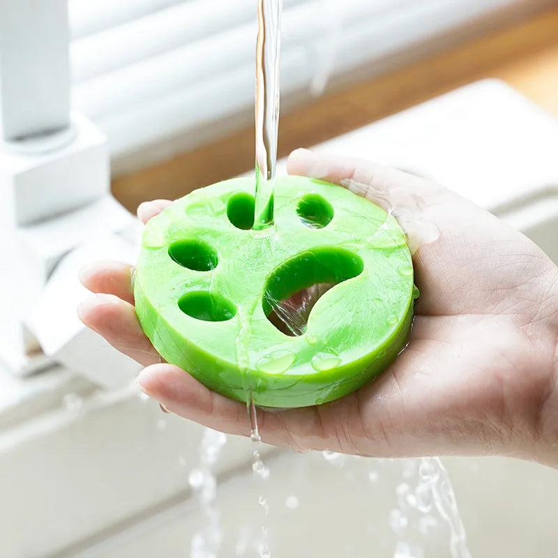 Reusable green pet hair remover rinsed under running water for easy cleaning and reuse