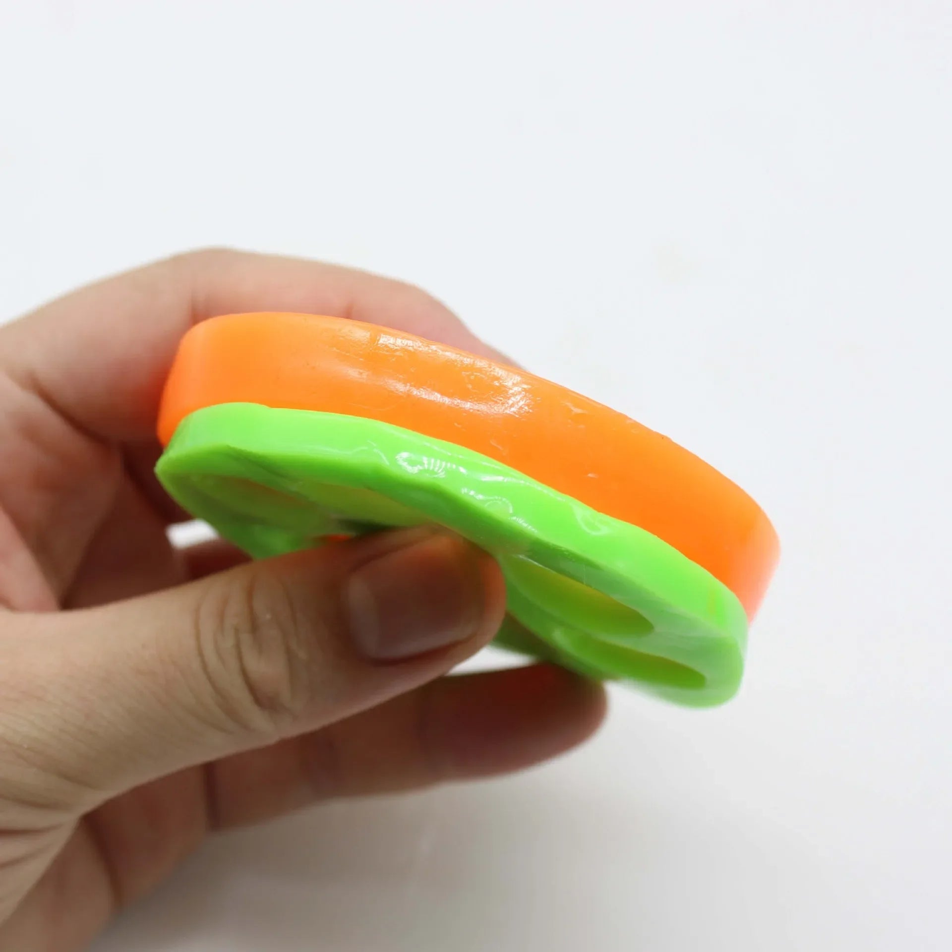 Close-up of green and orange reusable pet hair remover showing thickness and sticky surface